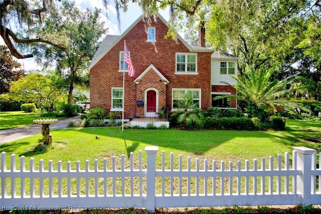 1237 Hotiyee Ave, Sebring, FL 33870 - english style home with a fenced front yard, brick siding, and a chimney