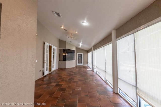 corridor with french doors and vaulted ceiling