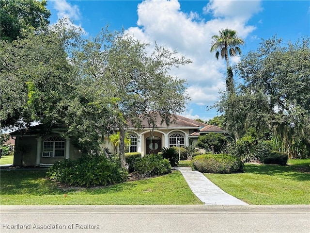 mediterranean / spanish-style home featuring a front yard