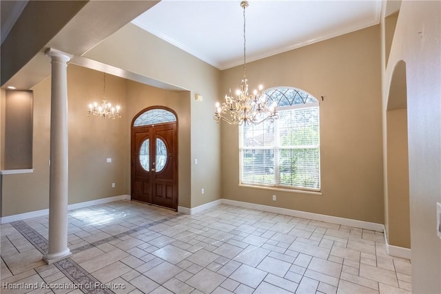 foyer entrance with a notable chandelier, ornate columns, and crown molding