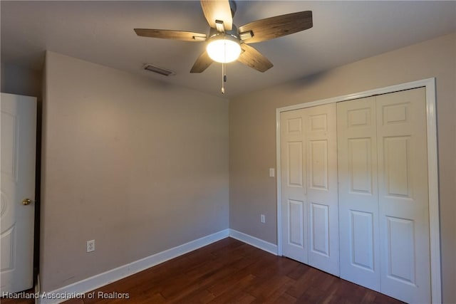 unfurnished bedroom with dark hardwood / wood-style flooring, ceiling fan, and a closet