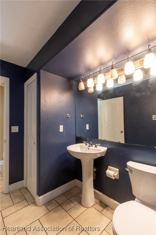 bathroom featuring tile patterned floors, toilet, and a textured ceiling