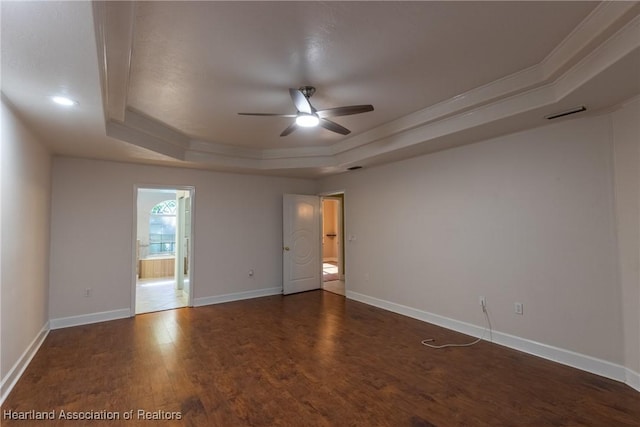 spare room with dark hardwood / wood-style flooring, a tray ceiling, ceiling fan, and crown molding