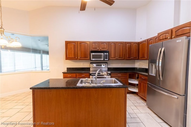 kitchen with sink, an island with sink, stainless steel appliances, and decorative light fixtures