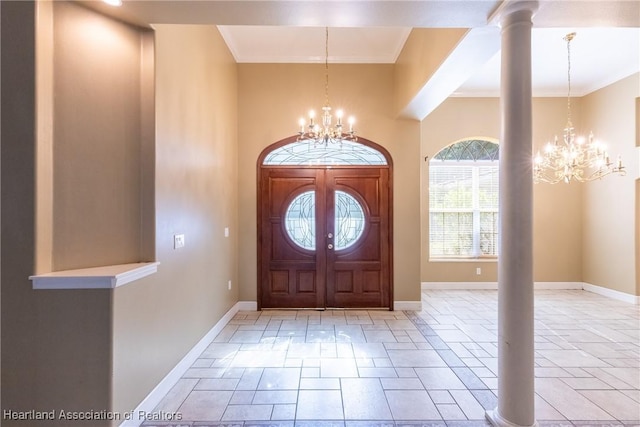 entrance foyer with decorative columns, french doors, crown molding, and a chandelier