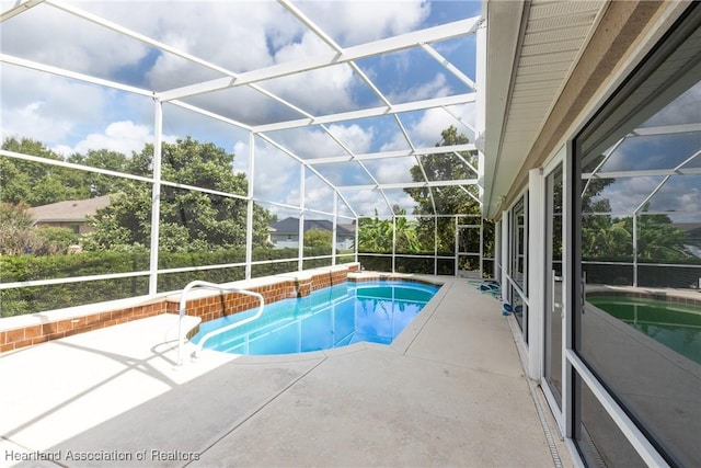 view of swimming pool featuring a lanai and a patio area