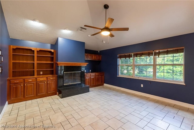 unfurnished living room with ceiling fan and a fireplace