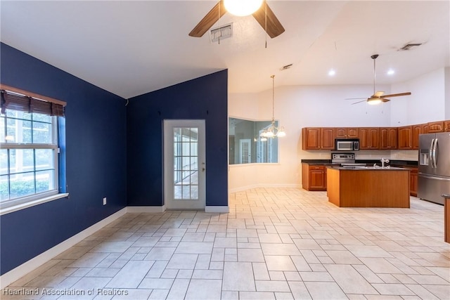 kitchen featuring appliances with stainless steel finishes, vaulted ceiling, sink, a kitchen island, and hanging light fixtures