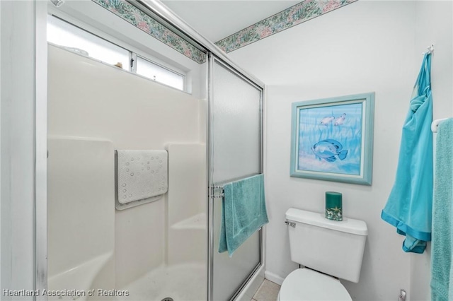 bathroom with a shower with shower door and toilet