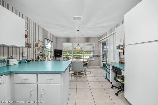 kitchen featuring white cabinetry, light tile patterned floors, and hanging light fixtures