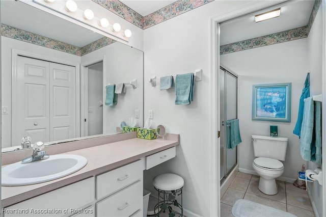 bathroom featuring tile patterned floors, vanity, an enclosed shower, and toilet