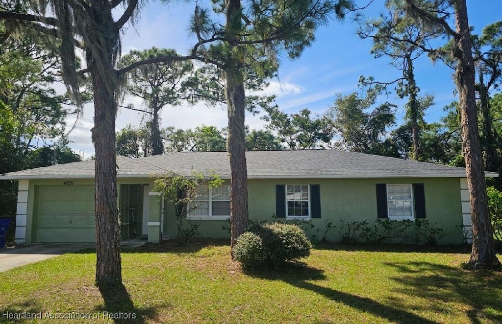 ranch-style house with a garage and a front lawn