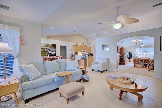 tiled living room with ceiling fan with notable chandelier and vaulted ceiling