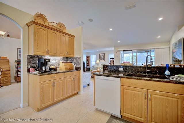 kitchen featuring dishwasher, light tile patterned flooring, sink, and dark stone counters