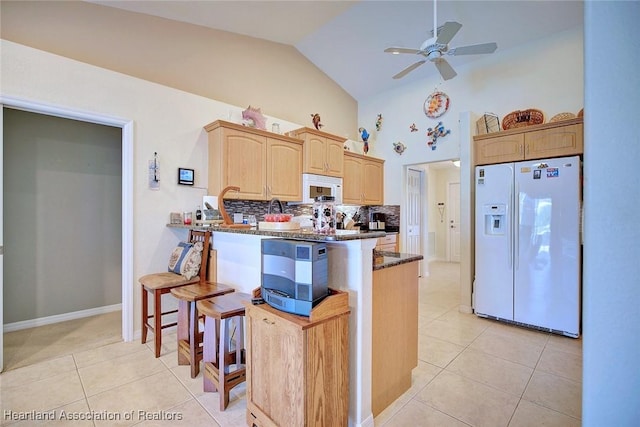 kitchen with light brown cabinets, white appliances, tasteful backsplash, and light tile patterned flooring