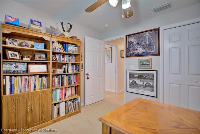 carpeted home office with ceiling fan