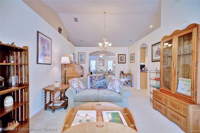 carpeted living room with ceiling fan with notable chandelier