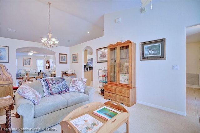 carpeted living room featuring ceiling fan with notable chandelier