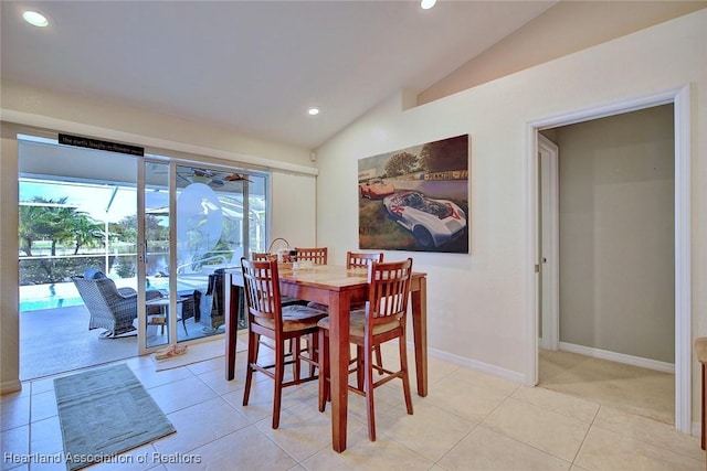 dining space with light tile patterned floors and vaulted ceiling