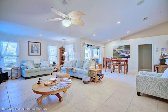 living room with ceiling fan, lofted ceiling, and light tile patterned floors