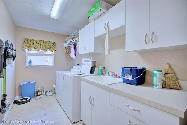 laundry room with cabinets, light tile patterned flooring, washer and clothes dryer, and sink