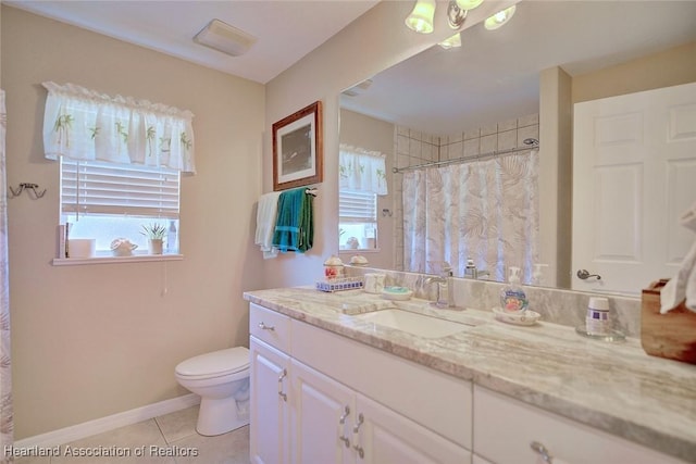 bathroom with toilet, vanity, and tile patterned floors