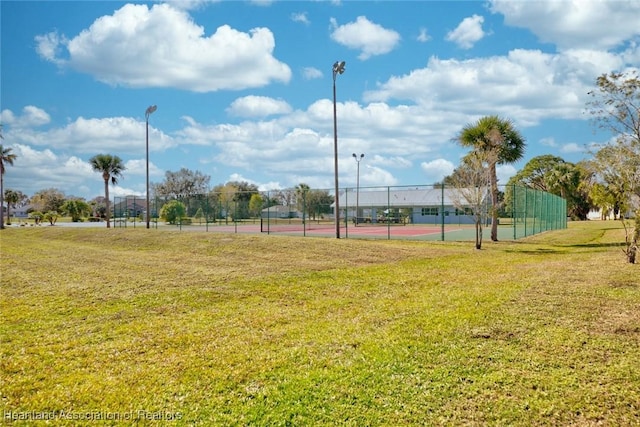 view of community featuring a lawn and tennis court