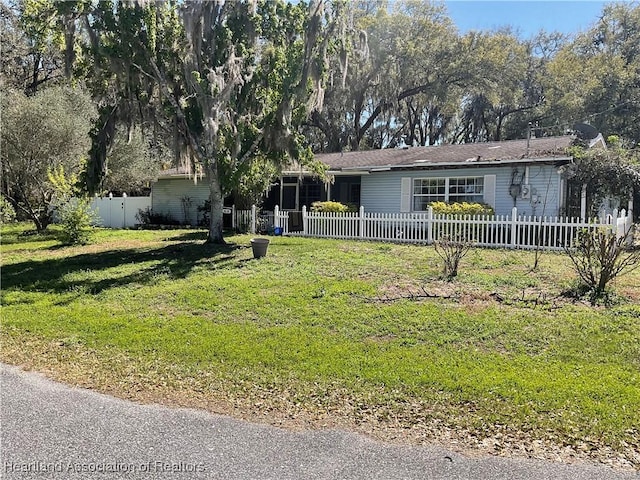 ranch-style home with a fenced front yard and a front lawn