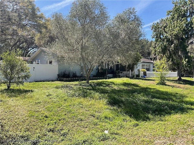 view of front of home featuring fence and a front yard