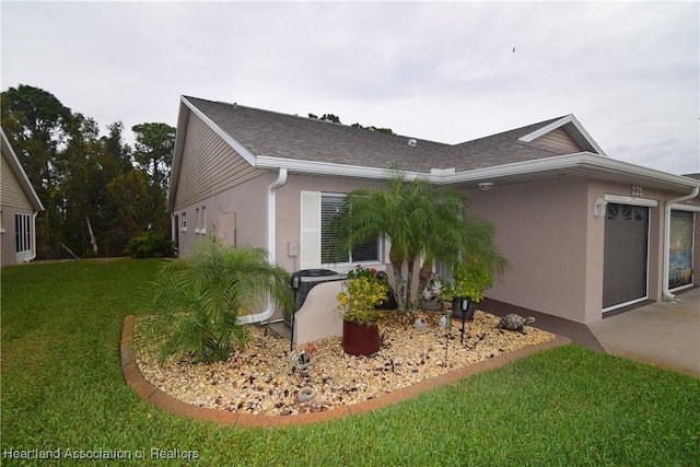 view of side of property featuring a lawn and a garage