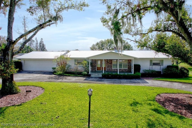 ranch-style house featuring a garage and a front lawn