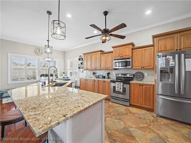 kitchen with sink, a kitchen island with sink, hanging light fixtures, and stainless steel appliances