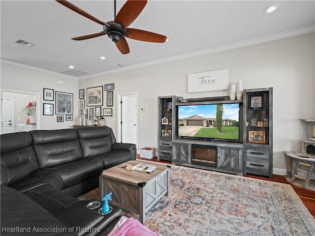 living room featuring crown molding, wood-type flooring, and ceiling fan