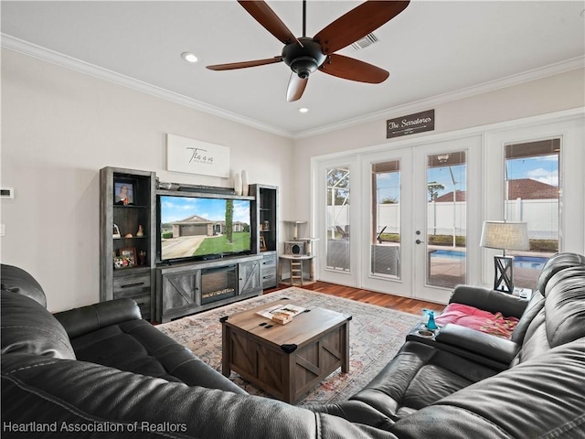 living room with ceiling fan, french doors, ornamental molding, and hardwood / wood-style floors