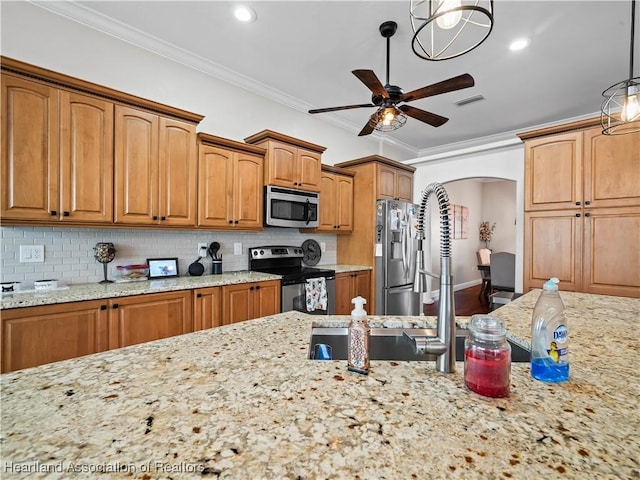 kitchen with pendant lighting, appliances with stainless steel finishes, ceiling fan, backsplash, and light stone counters