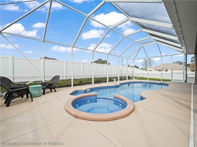 view of swimming pool with an in ground hot tub, a lanai, and a patio