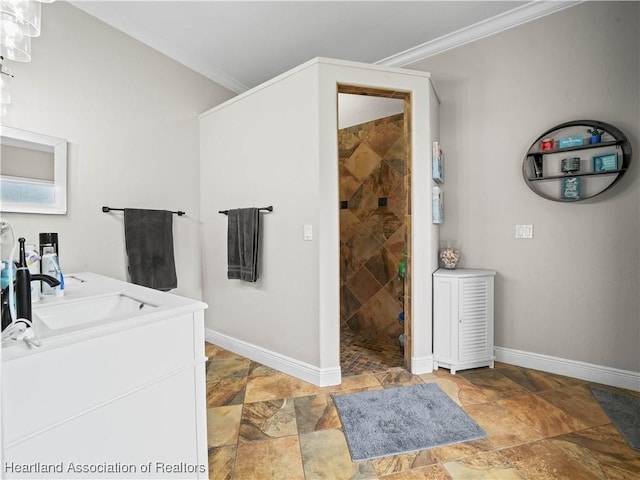 bathroom with vanity, tiled shower, and crown molding