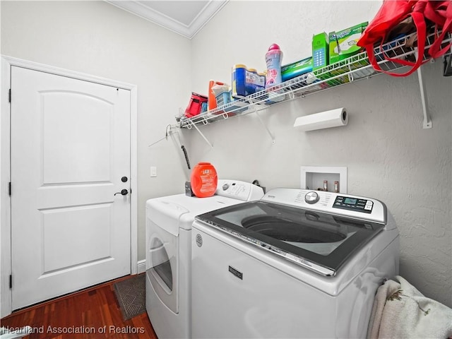 laundry room featuring washing machine and dryer, ornamental molding, and dark hardwood / wood-style flooring