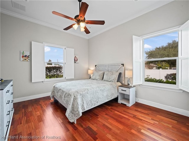 bedroom with ceiling fan, crown molding, dark wood-type flooring, and multiple windows