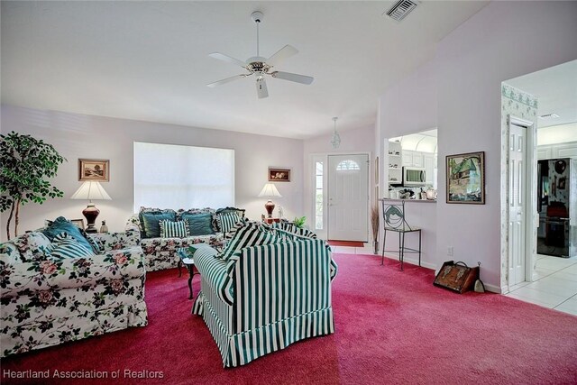 carpeted living room with ceiling fan and high vaulted ceiling