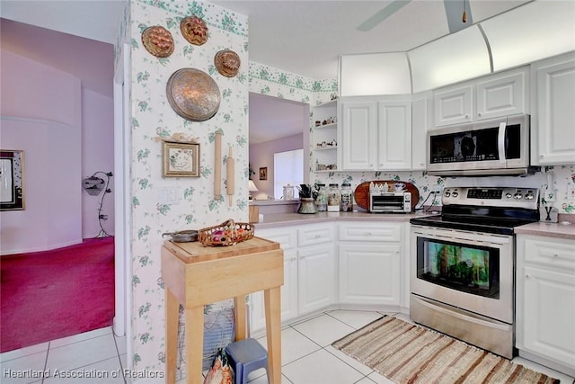 3171 E Pebble Dr, Avon Park, FL 33825 - kitchen featuring white cabinetry, light countertops, stainless steel appliances, wallpapered walls, and light tile patterned flooring