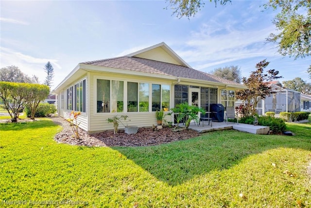 3171 E Pebble Dr, Avon Park, FL 33825 - rear view of property featuring a sunroom, roof with shingles, a yard, and a patio area