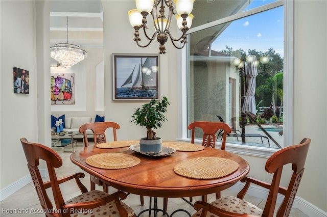 tiled dining room with an inviting chandelier