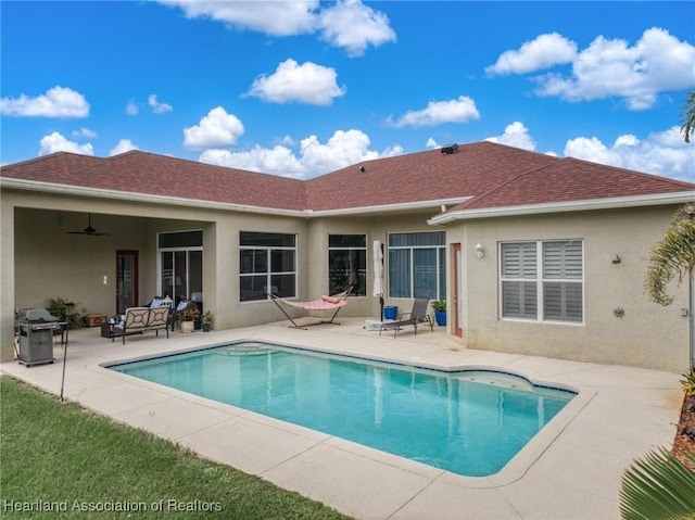 view of pool featuring outdoor lounge area, grilling area, ceiling fan, and a patio area