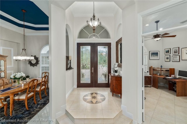 tiled foyer with french doors, ceiling fan, and ornamental molding