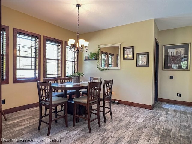 dining area with dark hardwood / wood-style flooring and a notable chandelier