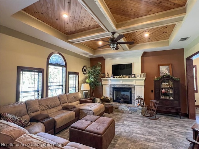 living room featuring ornamental molding, coffered ceiling, wood ceiling, ceiling fan, and a fireplace