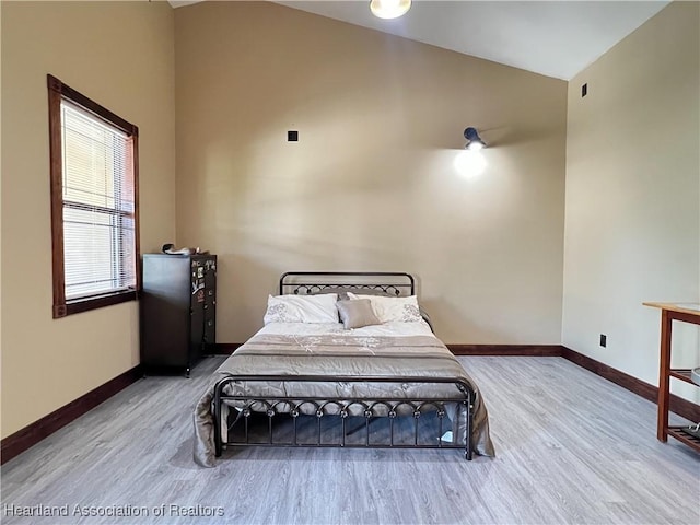 bedroom featuring hardwood / wood-style floors and vaulted ceiling