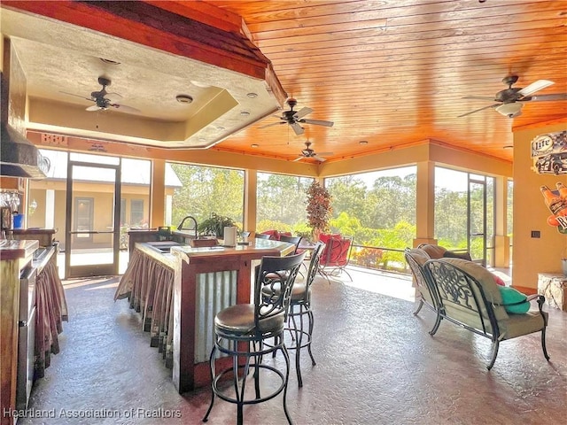 sunroom with wooden ceiling and sink