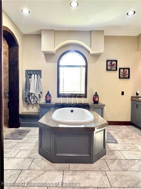 bathroom featuring a bathing tub, tile patterned flooring, and vanity